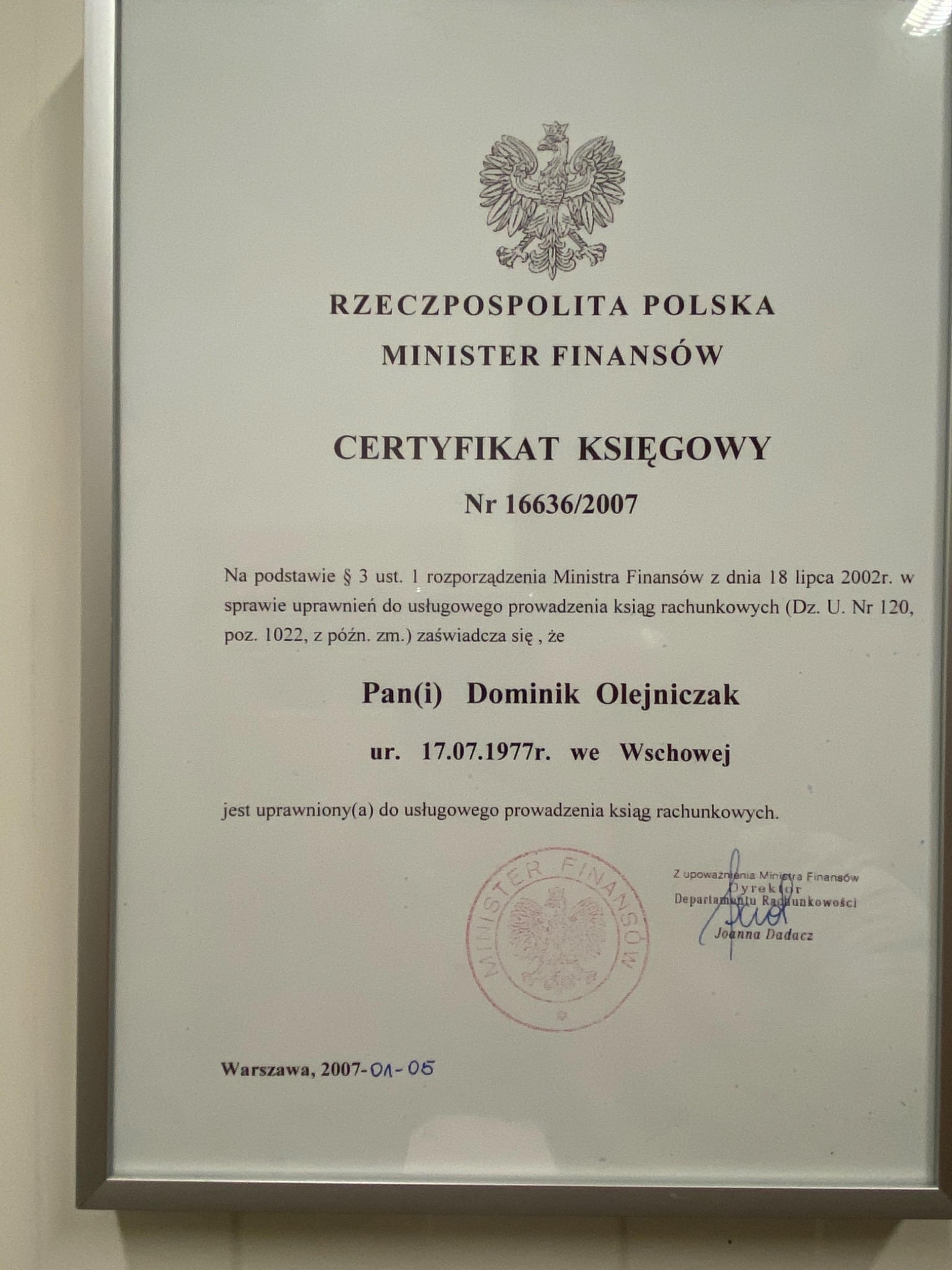 Skan certyfikatu księgowego wydanego przez Ministra Finansów Rzeczypospolitej Polskiej dla Dominika Olejniczaka, oprawiony w ramkę.
