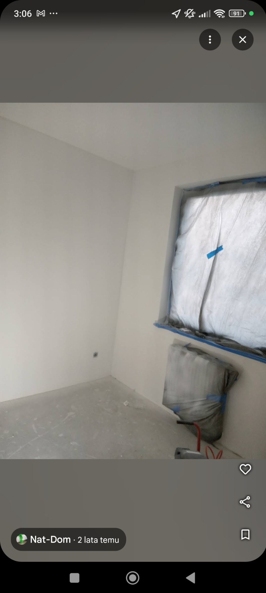 Pokój po malowaniu na biało, okno zabezpieczone folią malarską, widoczne ślady farby na podłodze.