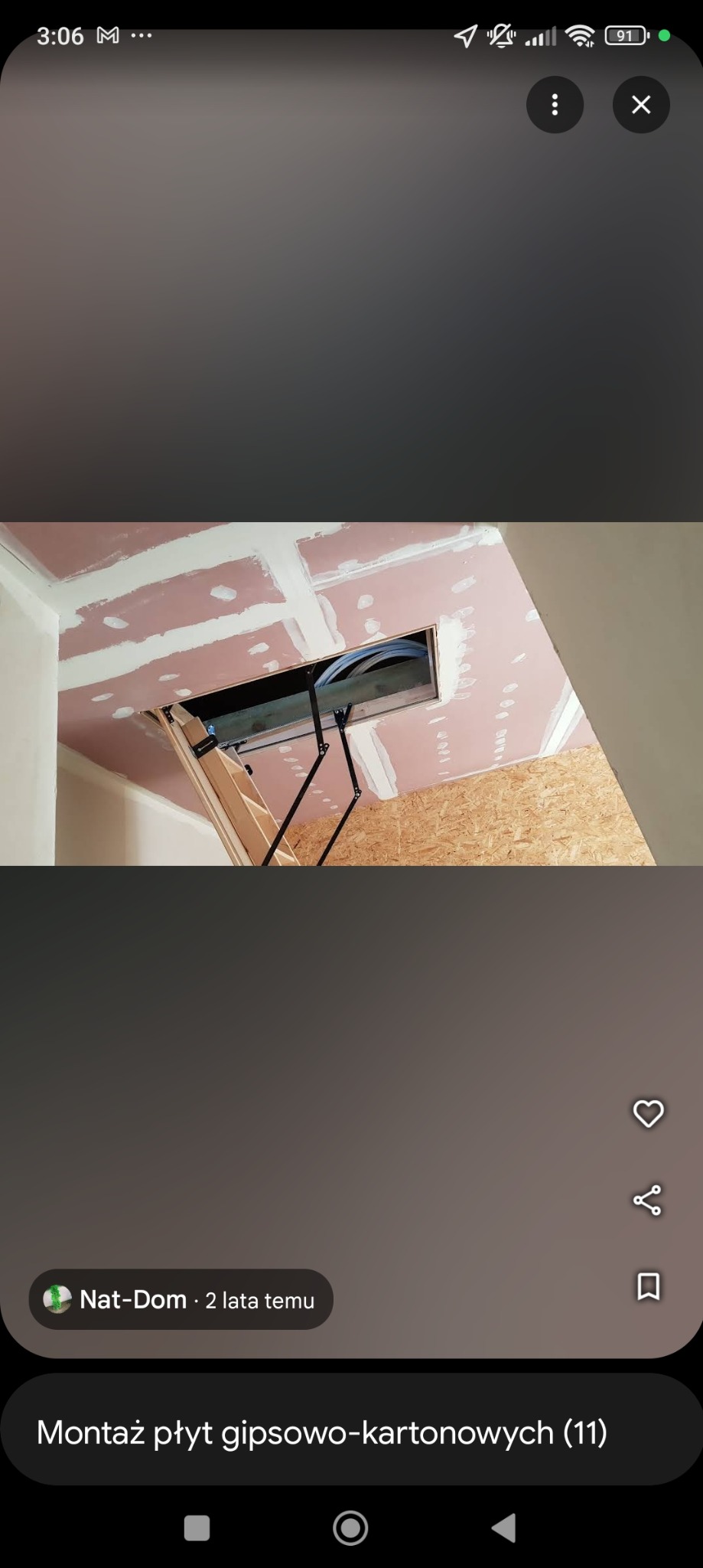 Montaż płyt gipsowo-kartonowych na suficie poddasza z widocznym włazem strychowym i schodami rozkładanymi, częściowo wykończone szpachlowaniem.