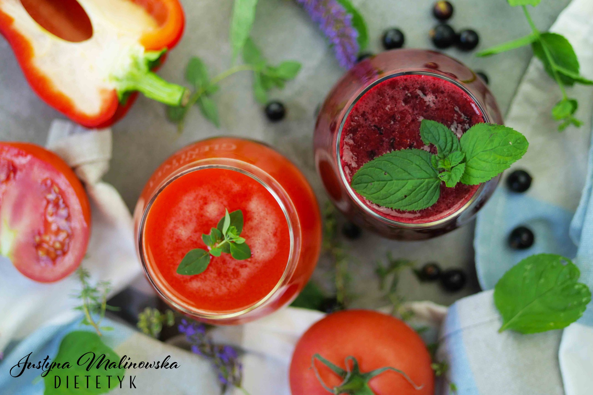 Dwa koktajle: pomidorowy i jagodowy, udekorowane listkami ziół, na tle z warzywami i owocami oraz podpisem 'Justyna Malinowska Dietetyk'.