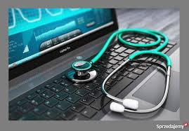 Laptop z wyświetlonym wykresem medycznym na ekranie i zielonym stetoskopem leżącym na klawiaturze.