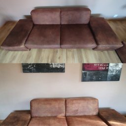 Mr.Mop Urszula Urbańczyk - Brązowa, dwuosobowa kanapa z widocznymi śladami użytkowania, sfotografowana z dwóch różnych perspektyw na tle ściany z obrazami.