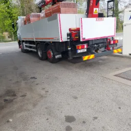 Ciężarówka z dźwigiem marki Fassi załadowana cegłami Termoton na stacji paliw Orlen z dystrybutorem AdBlue. Widoczny numer rejestracyjny DTR 92818.