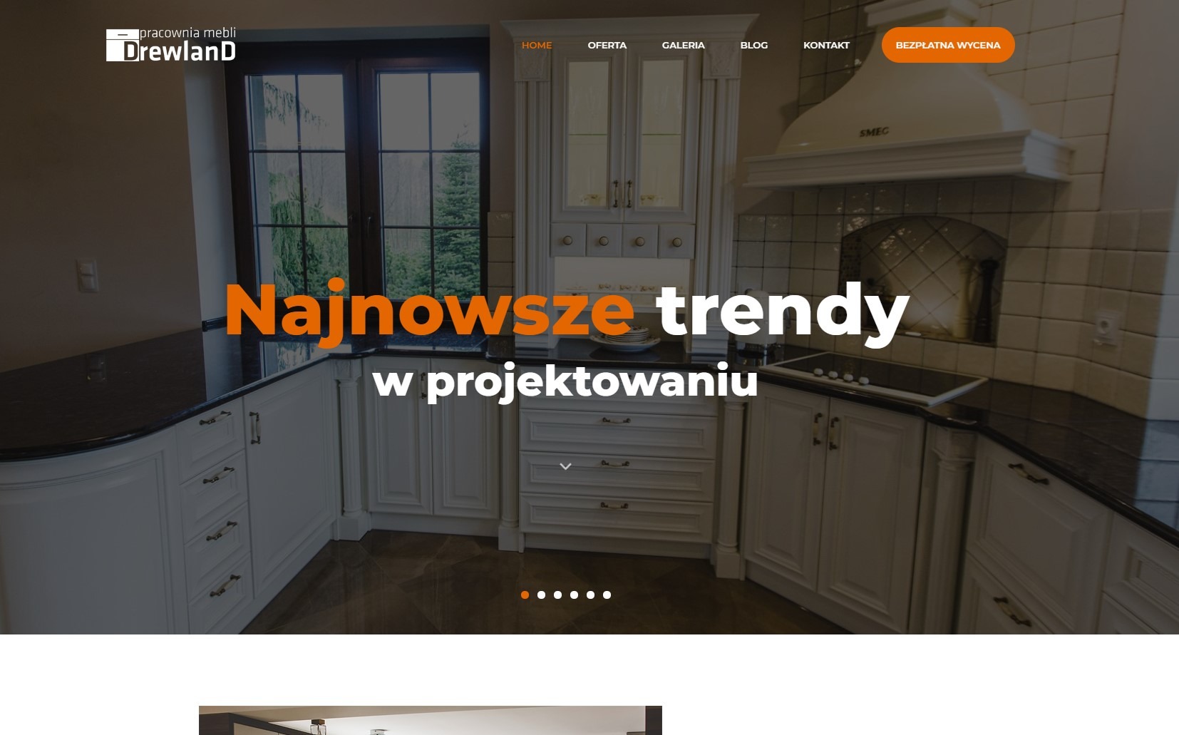 Strona internetowa pracowni mebli Drewland prezentująca aranżację kuchni w stylu klasycznym z białymi szafkami, czarnym blatem i okapem SMEG.