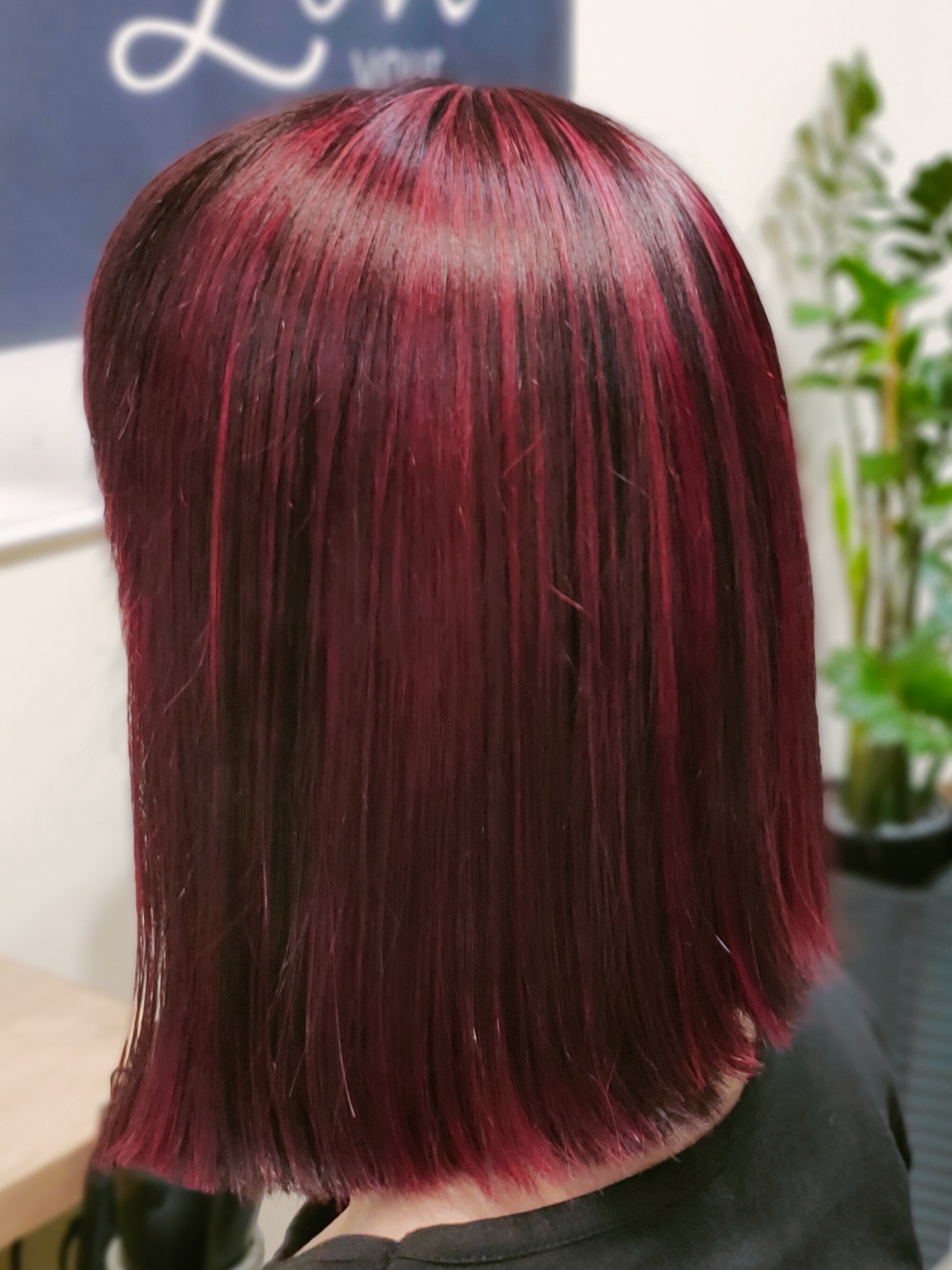 Ciemne włosy z burgundowymi pasemkami, świeżo po koloryzacji, krótka fryzura bob, widok z tyłu.