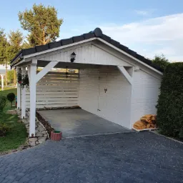 Wiata samochodowa z pomieszczeniem gospodarczym z boku.