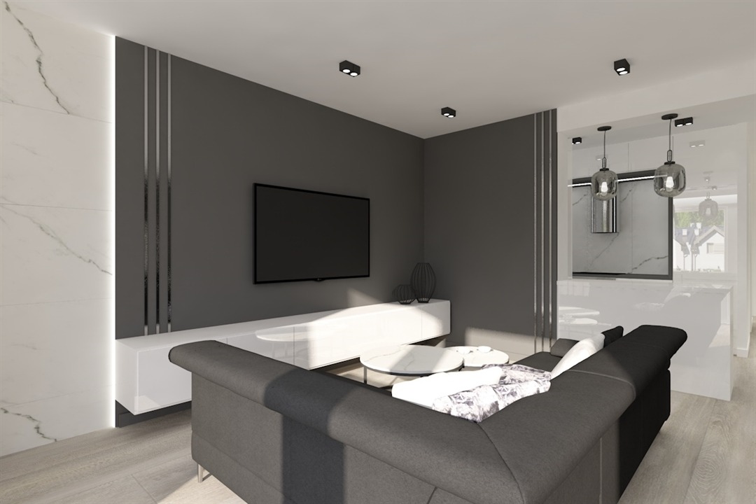 Nowoczesny salon z szarą sofą, białymi meblami RTV, marmurową ścianą i widoczną kuchnią w tle, oświetlony punktowymi lampami sufitowymi.