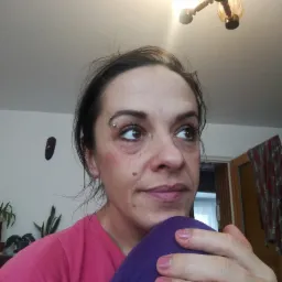 Portret kobiety z kolczykiem w brwi, spoglądającej w górę, w tle widoczny żyrandol i fragment pokoju w Dębicy.