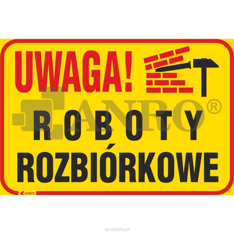Żółta tablica ostrzegawcza z napisem 'UWAGA! ROBOTY ROZBIÓRKOWE', ilustracją muru ceglanego i młotka.