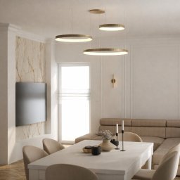 MP ARCHITEKTURA WNĘTRZ PAULINA TRACZ - Elegancka jadalnia w beżach: stół z dekoracjami, krzesła, sofa narożna, marmurowa ściana z TV, okrągłe lampy wiszące i kinkiety. Subtelne oświetlenie.