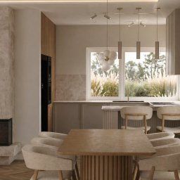 MP ARCHITEKTURA WNĘTRZ PAULINA TRACZ - Jasne wnętrze z kominkiem obłożonym marmurem, drewnianym stołem i krzesłami. W tle okno z widokiem na zieleń. Minimalistyczny design z elementami naturalnymi.