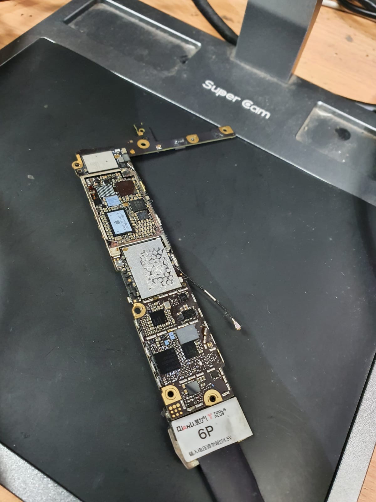 Płyta główna iPhone 6P pod mikroskopem Super Cam, widoczne liczne komponenty i ślady napraw.