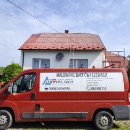 Complex-Dach Dawid Dębski - Czerwony samochód dostawczy firmy Complex-Dach z reklamą malowania dachów i elewacji na tle domu z pomalowanym na czerwono dachem, drabina oparta o dach, widoczne narzędzia na dachu, słoneczny dzień.