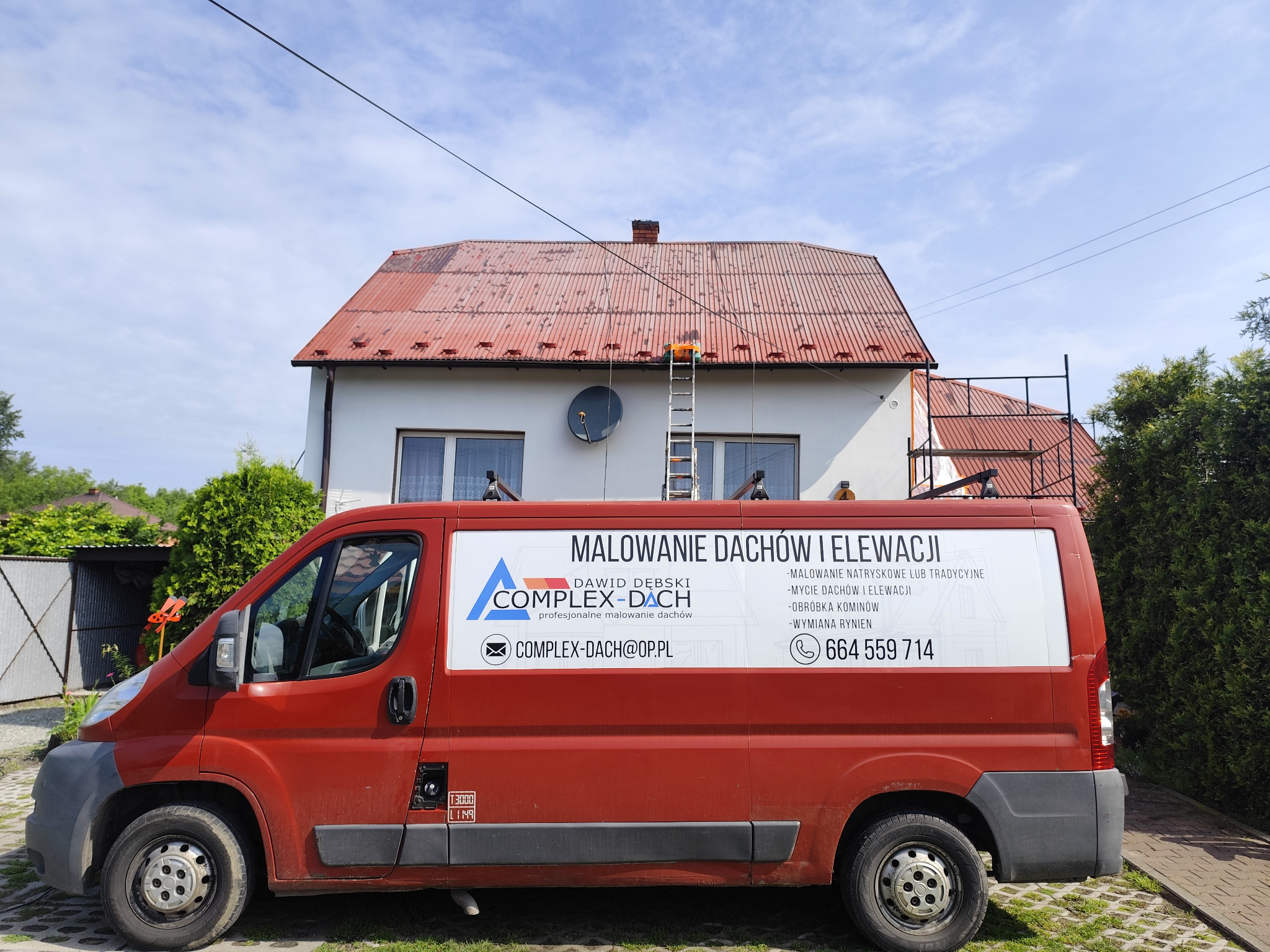 Czerwony samochód dostawczy firmy Complex-Dach z reklamą malowania dachów i elewacji na tle domu z pomalowanym na czerwono dachem, drabina oparta o dach, widoczne narzędzia na dachu, słoneczny dzień.