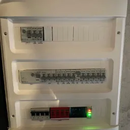 Rozdzielnica elektryczna z zabezpieczeniami Eaton i Adelid, widoczne wyłączniki różnicowoprądowe RCD1 i RCD2, ograniczniki przepięć ELS oraz moduł zasilania z sygnalizacją LED.