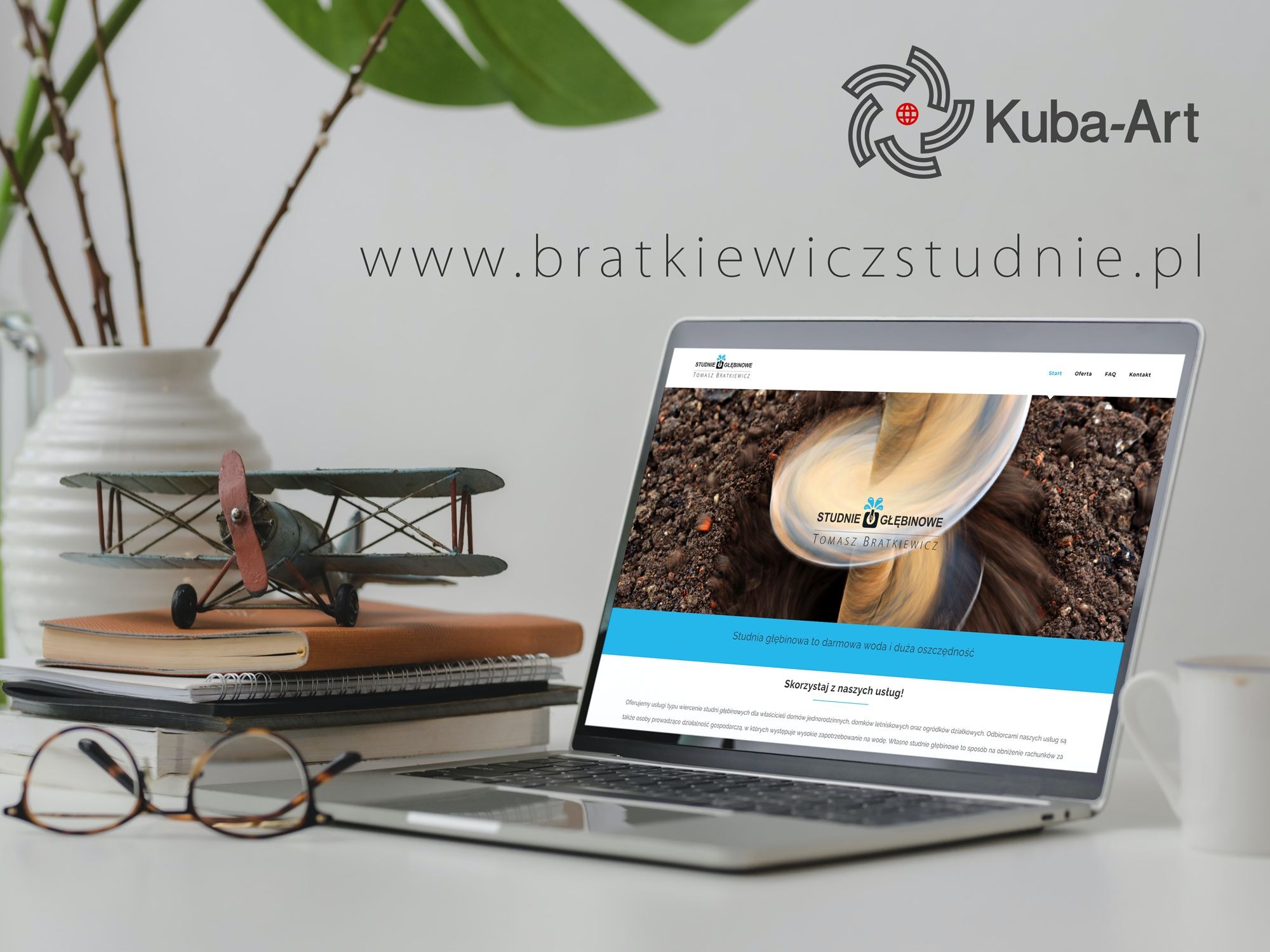 Laptop wyświetlający stronę internetową firmy Studnie Głębinowe Tomasz Bratkiewicz, z zabawką samolotu, okularami i wazonem obok. Widoczny adres strony www.bratkiewiczstudnie.pl i logo Kuba-Art.
