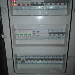 Rozdzielnica elektryczna Hager z widocznymi bezpiecznikami, ogranicznikami przepięć i sygnalizacją stanu, w obudowie z tworzywa sztucznego.