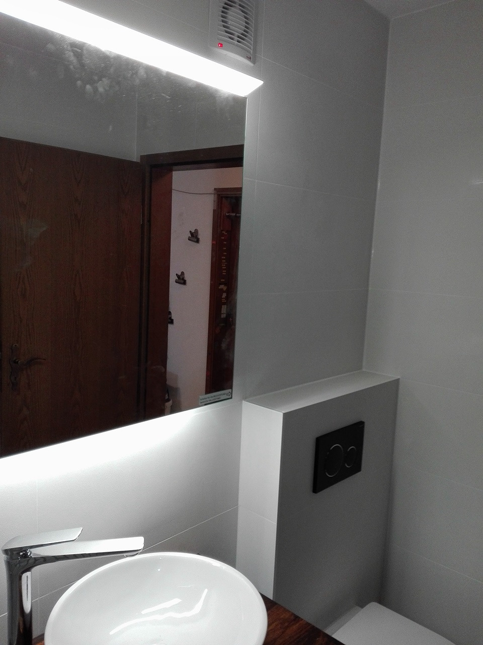 Nowoczesna łazienka w Krakowie z umywalką nablatową, lustrem z podświetleniem LED i ukrytą spłuczką w zabudowie.