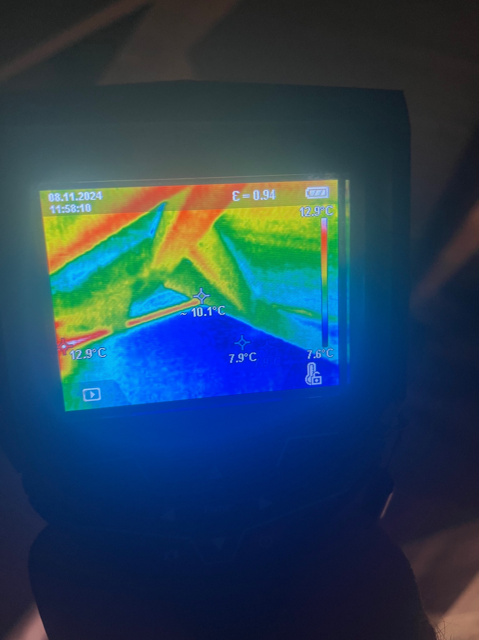 Termowizja dachu z widocznymi różnicami temperatur, prezentowana na ekranie urządzenia pomiarowego z datą 08.11.2024 i godziną 11:58. Kolorystyka od niebieskiego do czerwonego.