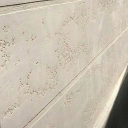 IVAD - Fragment elewacji z fakturą baranka, z widocznymi poziomymi liniami podziału, oświetlony z boku