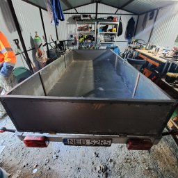 ARDSWELD Arkadiusz Dopierała - Spawana, metalowa przyczepa transportowa w warsztacie, widok z tyłu, z widoczną tablicą rejestracyjną i elementami konstrukcyjnymi spawanymi punktowo.