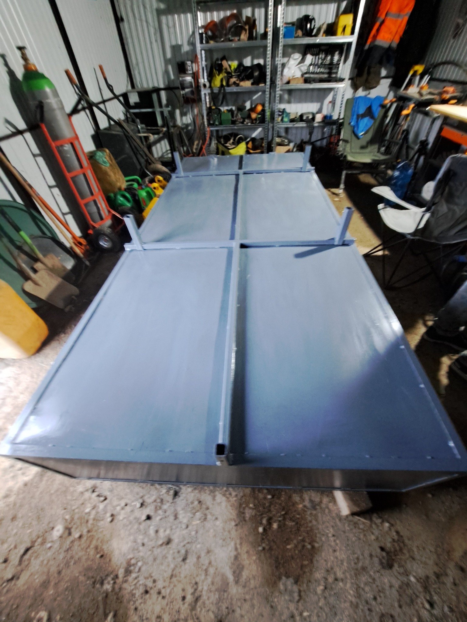 Szara, spawana konstrukcja stalowa z czterema panelami, widoczna w warsztacie z butlą gazową i regałami w tle.