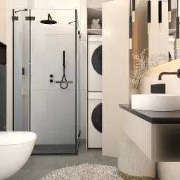 Nowoczesna łazienka z kabiną prysznicową typu walk-in, umywalką nablatową na blacie z czarnego marmuru i pralką ukrytą w zabudowie.