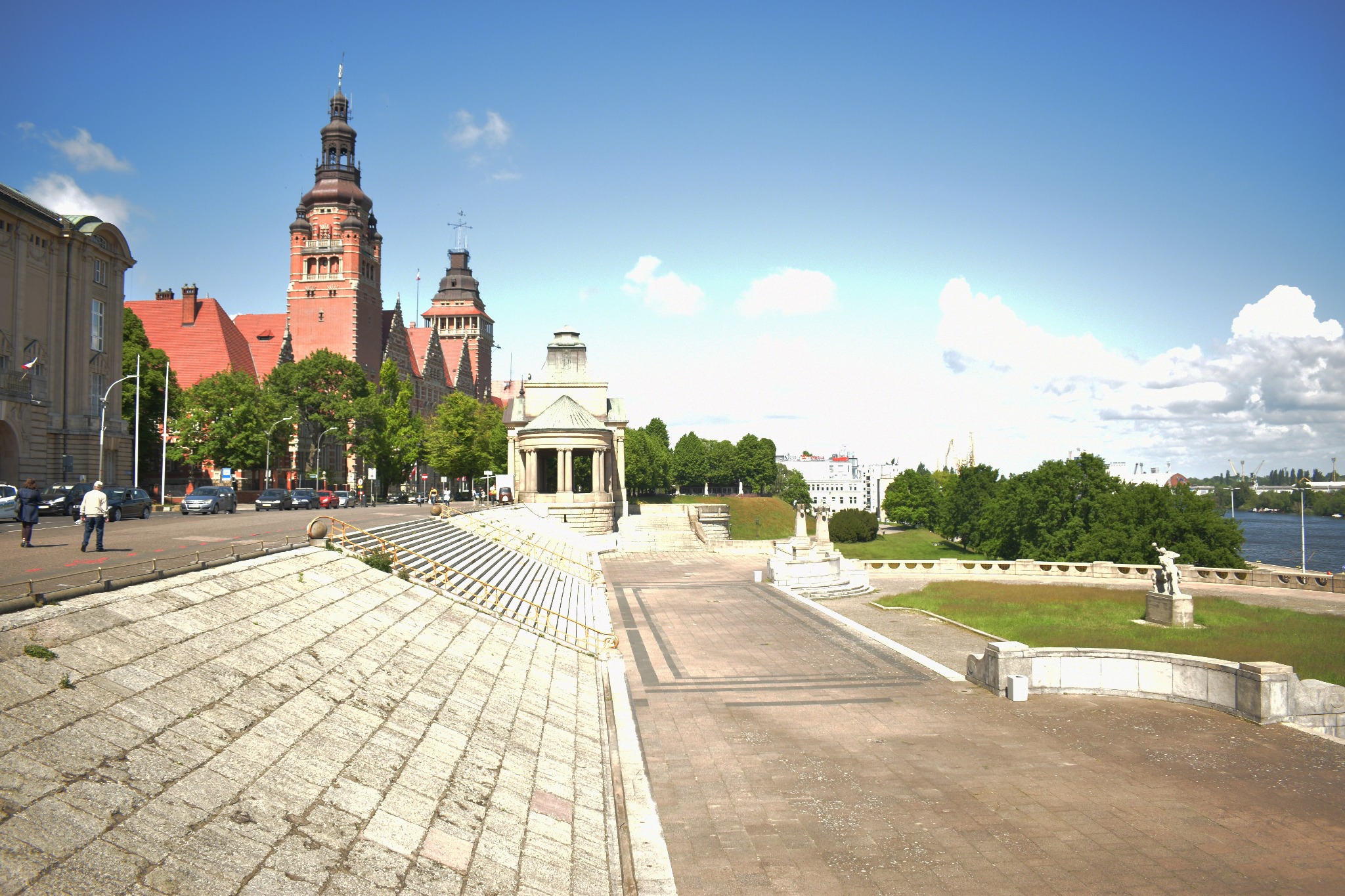 Panorama Szczecina z Wałów Chrobrego, widok na budynki z czerwonymi dachami i wieżami, w tle rzeka Odra.