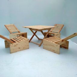 Najmart Sp. z o.o. - Komplet mebli ogrodowych z jasnego drewna: składany stół i cztery krzesła z oparciami, ustawione na białym tle. Widoczne detale konstrukcyjne i naturalny odcień drewna.