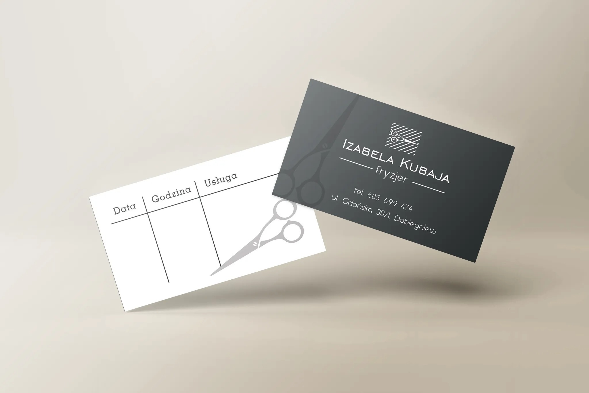 Dwie wizytówki fryzjerskie: ciemnoszara z danymi kontaktowymi 'Izabela Kubaja Fryzjer' i biała z tabelą na datę, godzinę i usługę, obie z motywem nożyczek.