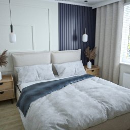 AP PROJEKT Andrzej Podraza - Jasna sypialnia z beżowym łóżkiem, niebieskim pledem, drewnianymi szafkami nocnymi i białymi lampami wiszącymi, widok na miasto za oknem.