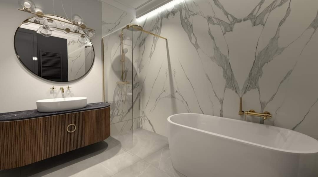 Nowoczesna łazienka z marmurową ścianą, owalną wanną i szafką pod umywalkę z drewnianymi lamelami oraz okrągłym lustrem z dekoracyjnym oświetleniem.