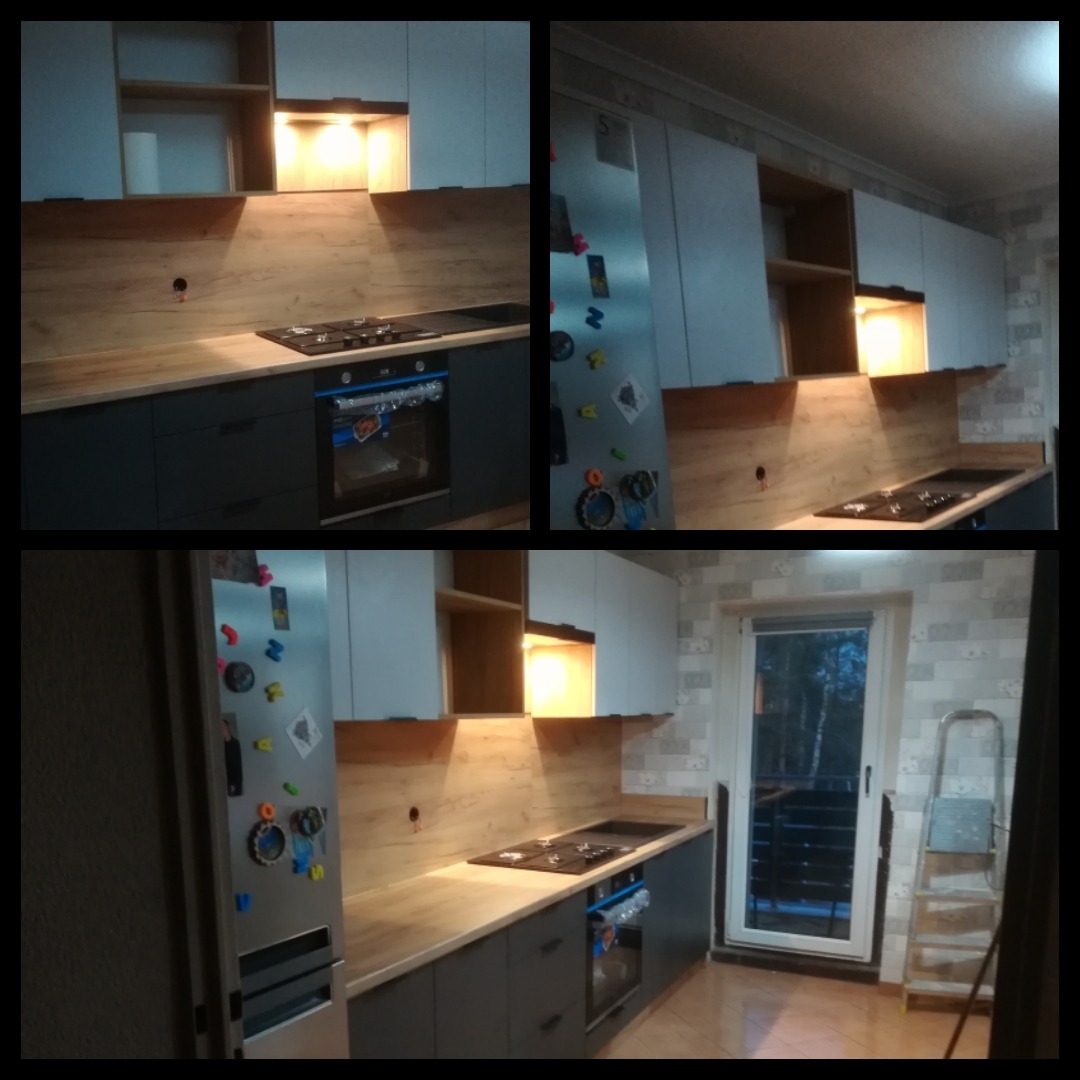 Nowoczesna kuchnia z szarymi szafkami, blatem imitującym drewno i oświetleniem podszafkowym, widok na płytę grzewczą i piekarnik, lodówka z magnesami.