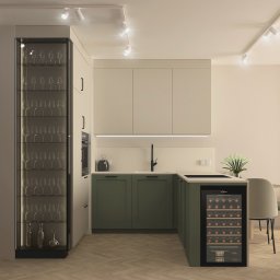 zboinskadesign - Nowoczesna kuchnia w odcieniach beżu i zieleni z szafką na wino, szklaną witryną na kieliszki i drewnianą podłogą w jodełkę. Oświetlenie punktowe.