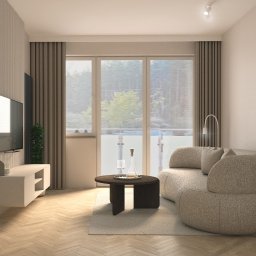 zboinskadesign - Jasne wnętrze salonu z parkietem w jodełkę, beżową sofą o organicznym kształcie i minimalistycznym stolikiem kawowym. Telewizor na ścianie i duże okno z widokiem na zieleń.