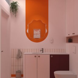 zboinskadesign - Nowoczesna łazienka z pomarańczową ścianą akcentową, falistym lustrem, szafką pod umywalkę w kolorze beżowo-brązowym, wiszącą rośliną i geometrycznymi płytkami podłogowymi.