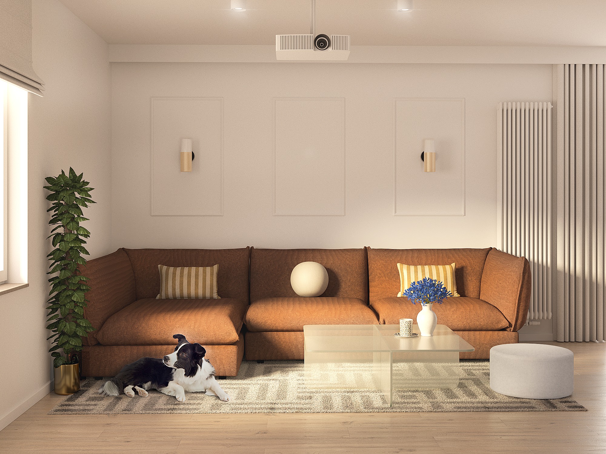 Salon z brązową sofą modułową, szklanym stolikiem kawowym, rośliną doniczkową w złotej osłonce, psem rasy border collie leżącym na dywanie oraz projektorem zamontowanym na suficie.