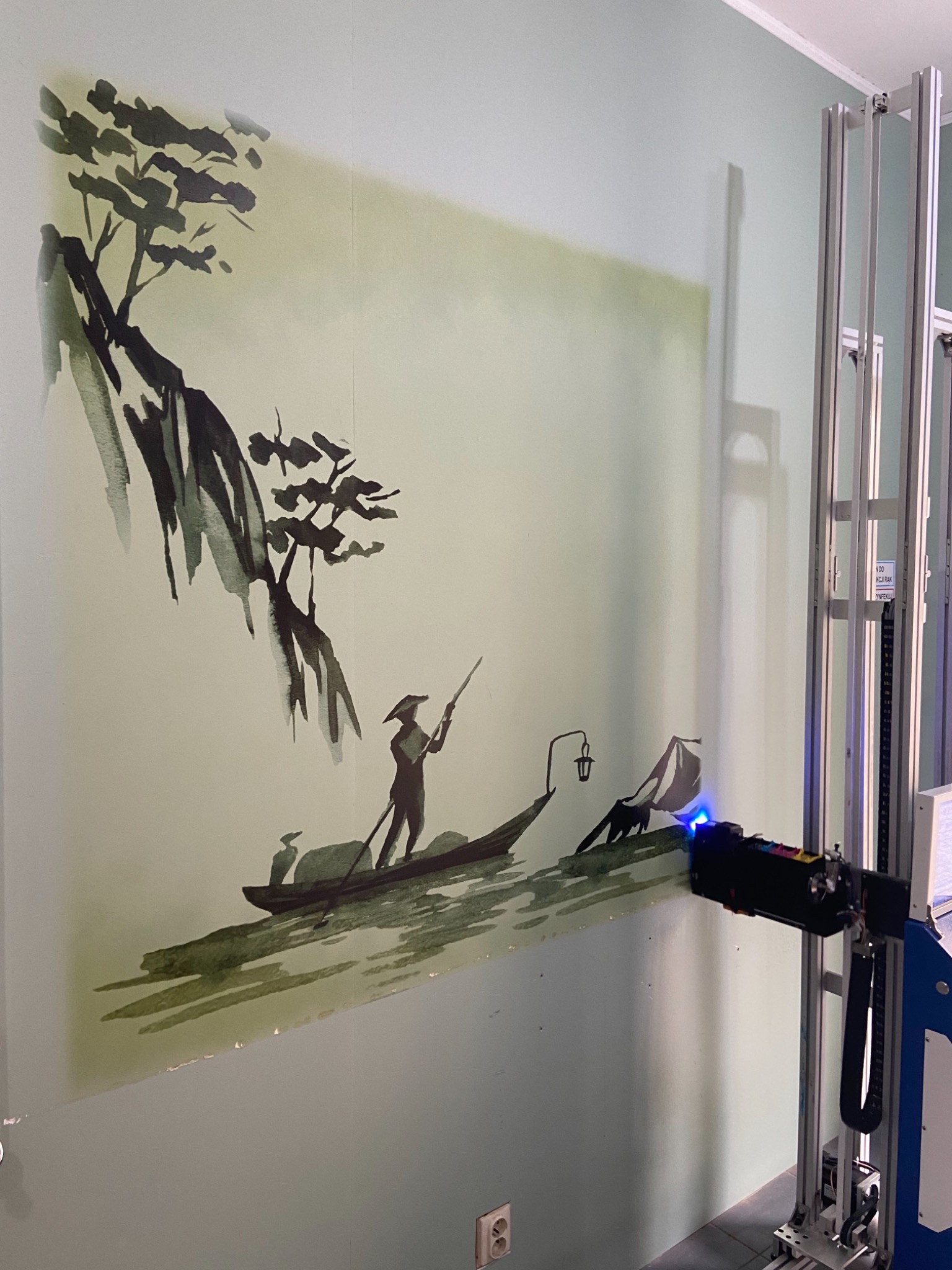 Ściana z malowidłem w stylu japońskim przedstawiającym rybaka na łodzi, wykonywana za pomocą pionowej drukarki ściennej.