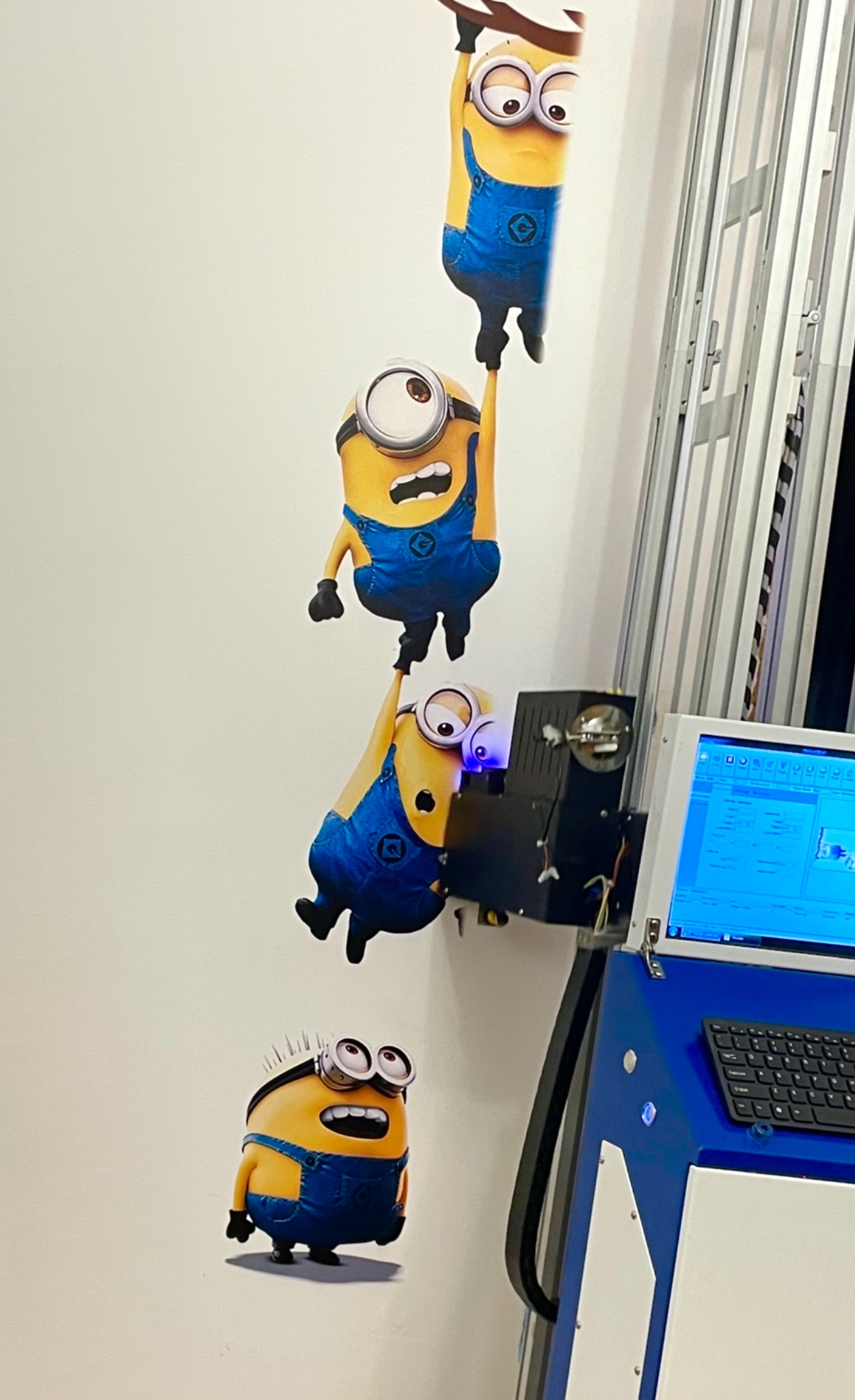 W Poznaniu, drukarka pionowa drukuje na ścianie postacie Minionków, tworząc dekoracyjny mural w pokoju dziecięcym.