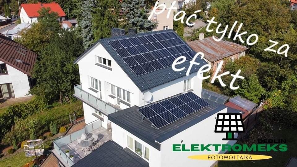Widok z góry na dom z panelami słonecznymi na dachu i logo firmy na ścianie. Na zdjęciu widoczny napis 'Płać tylko za efekt'.