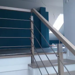 Fragment schodów z drewnianymi stopniami i balustradą z drewnianą ramą i stalowymi linkami w domu w Błażowej, widok z dołu.