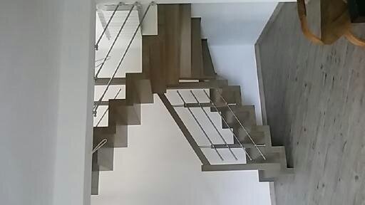 Nowoczesne schody drewniane z metalowymi balustradami, widok z góry, minimalistyczny design.