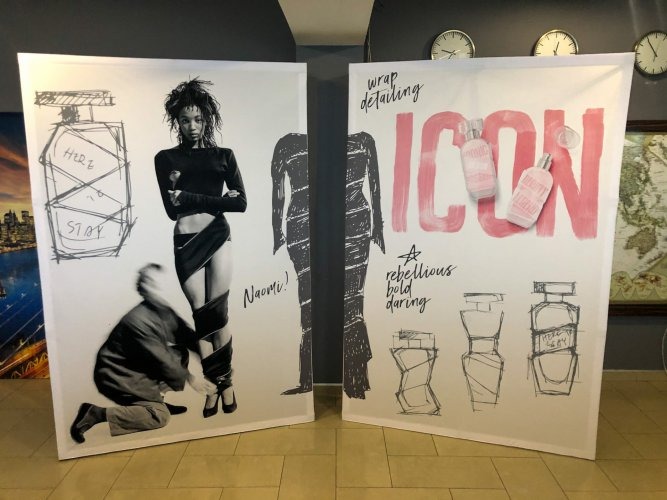 Dwa duże panele reklamowe z grafiką: lewy z czarno-białym portretem kobiety i szkicem flakonu perfum, prawy z napisem 'ICON' i wizualizacją produktu.