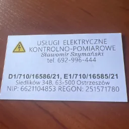 Wizytówka firmy oferującej usługi elektryczne kontrolno-pomiarowe, z symbolem ostrzeżenia o wysokim napięciu, danymi kontaktowymi i adresowymi.
