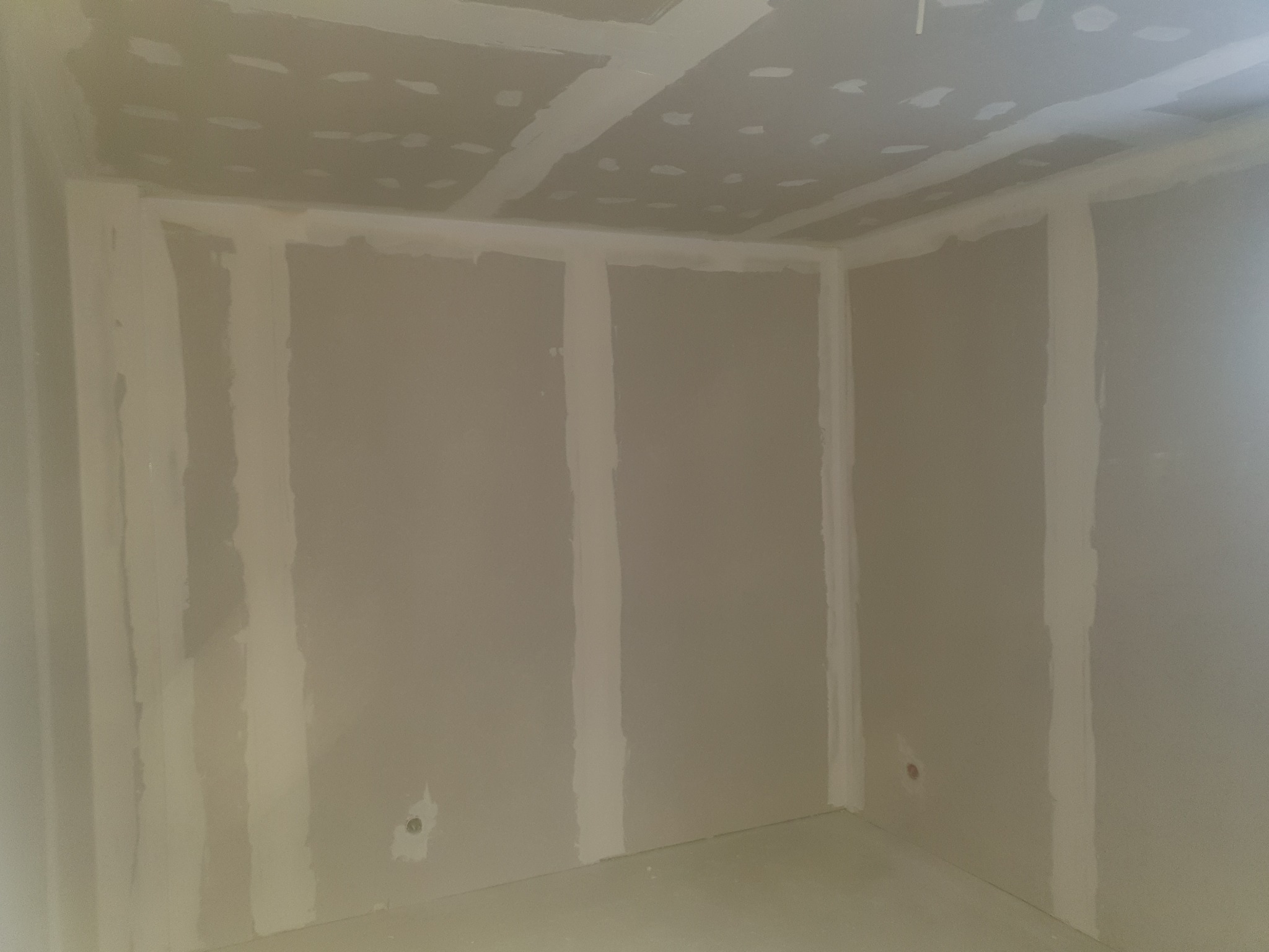 Wnętrze po montażu płyt gipsowo-kartonowych i szpachlowaniu w Buk. Widoczne łączenia płyt na ścianach i suficie, przygotowane do dalszych prac wykończeniowych.