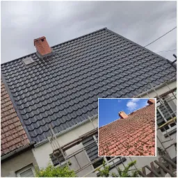 Nowy, ciemnoszary dach z blachy trapezowej z oknem dachowym i kominem z czerwonej cegły, widoczny fragment starego dachu w rogu zdjęcia, pochmurne niebo.