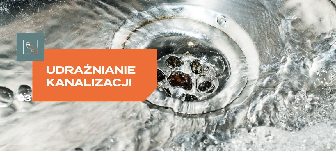 Krople wody spływające do metalowego odpływu zlewu, z widoczną blokadą z resztek i pomarańczowym banerem z napisem 'Udrażnianie kanalizacji'.