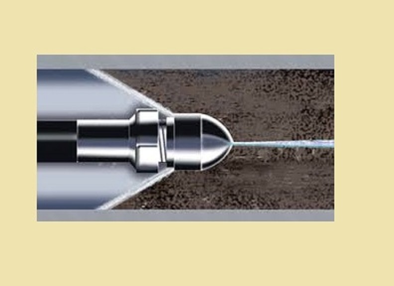 Schematyczny widok dyszy ciśnieniowej wprowadzanej do rury kanalizacyjnej, ilustrujący proces strumieniowego czyszczenia z zanieczyszczeń.