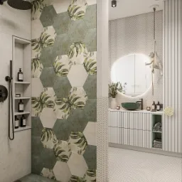 Nowoczesna łazienka z heksagonalnymi płytkami w odcieniach zieleni i beżu z motywem liści, kabina prysznicowa typu walk-in, okrągłe lustro z podświetleniem i dekoracyjna figurka małpy.