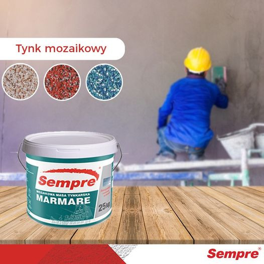 Puszka z mozaikową masą tynkarską Sempre Marmare na drewnianym blacie, w tle pracownik w żółtym kasku aplikujący tynk na ścianę, obok trzy próbki kolorystyczne tynku.